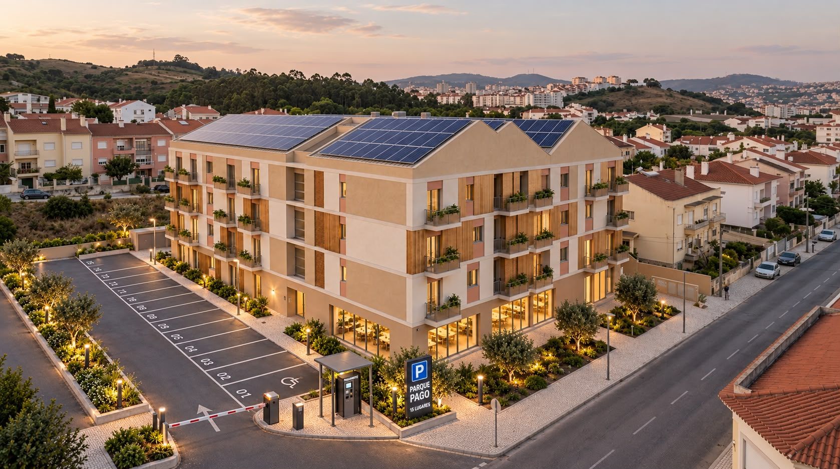 Fachada do edifício VERSO ao pôr do sol, com painéis solares na cobertura, varandas ajardinadas e o parque de estacionamento privado em primeiro plano